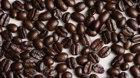 白色表面上旋转的咖啡豆