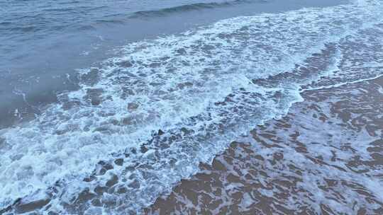 阴天大海沙滩航拍海岸海水拍打沙滩海浪潮水