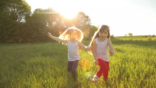 两个女孩在草地上玩追赶游戏