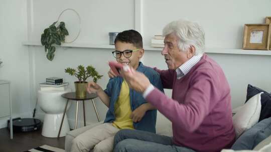 祖父和孙子一起玩电子游戏，一起加油