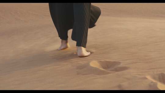 妇女赤脚在沙漠中行走的特写