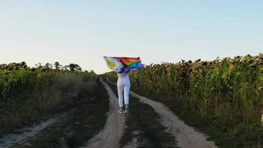 年轻女子在野外奔跑，彩虹LGBTQIA旗