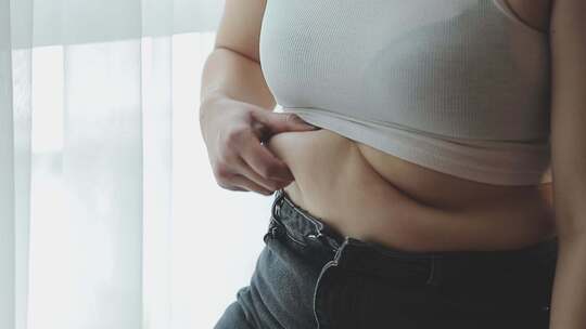 女人因为肥胖发愁摸着腰部赘肉视频素材模板下载