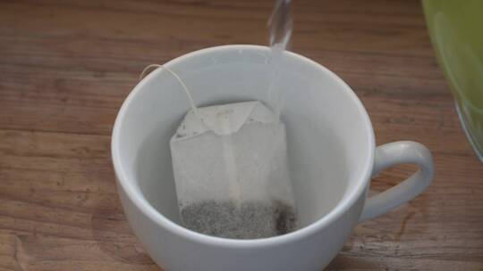 泡茶：用茶包在白杯中倒入热水。视频素材模板下载