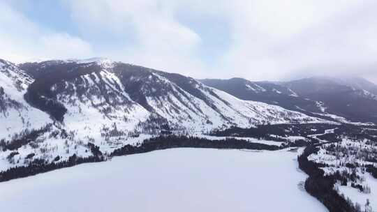 航拍新疆冬季喀纳斯湖雪景雪山森林冰河晨雾