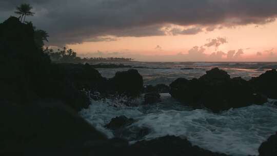 太阳落山时，海浪拍打着岩石