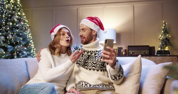 圣诞节夫妻使用手机和家人视频