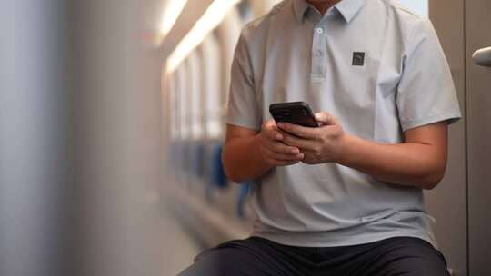 男子在卧铺火车过道上使用手机