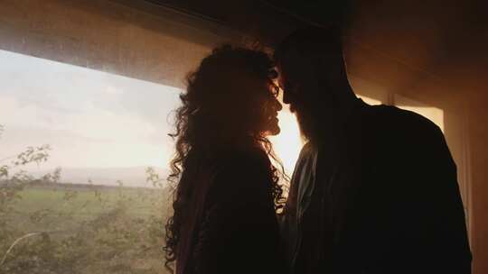 情侣亲吻靠近窗户剪影