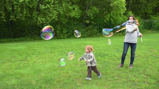 公园里快乐的家庭时刻，母亲在两个年幼的孩