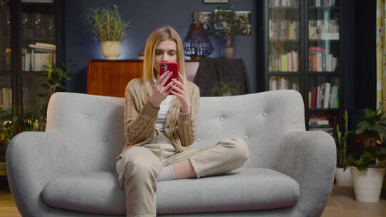 坐在沙发上使用手机的女人