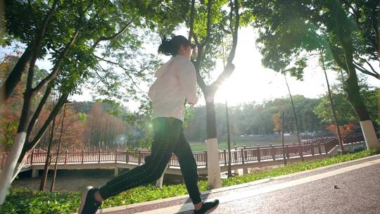 励志女孩在阳光下的公园绿道跑步视频素材