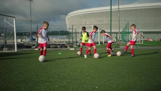 儿童足球运动员在足球场踢足球