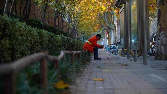 独自坐在路边看手机的环卫工人孤独背影视频素材模板下载