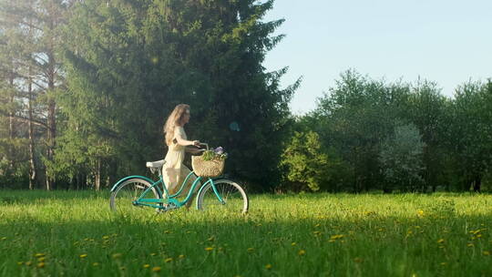 推着自行车在草地上行走的女人