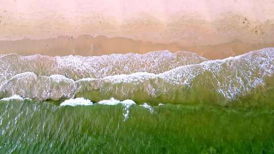 海滨城市高楼边的沙滩和海水景象