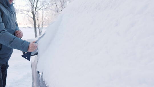 男人用刷子扫雪