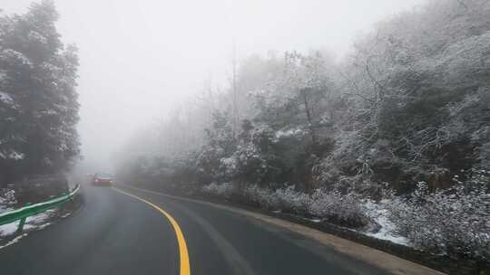 大雾雪天汽车行驶在山林公路