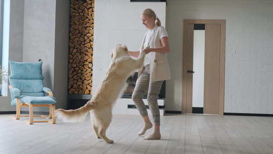 快乐的女人在家和狗跳舞