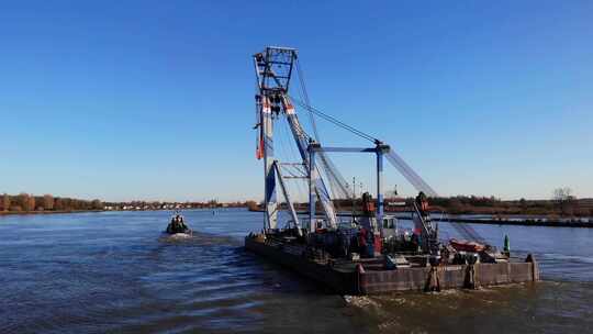 白天，在荷兰巴伦德雷赫特附近的河里，拖船拉着一条漂浮的大羊腿。-