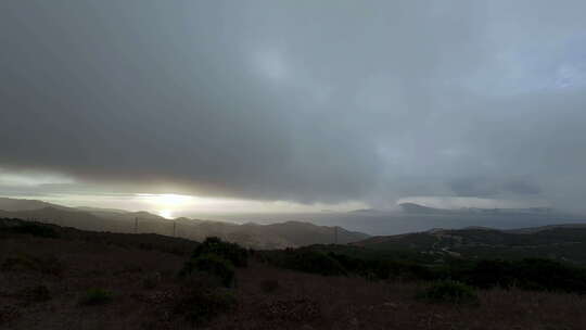 暴雨云层笼罩在黑暗的丘陵地带。