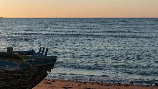 渔船破旧海滩傍晚海面海浪