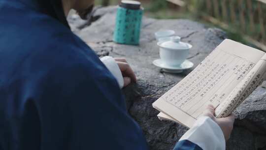 古代古人在石桌上喝茶看书闲情逸致视频素材模板下载