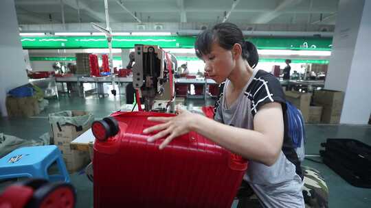 工厂女工加工红色行李箱