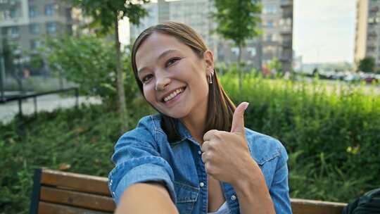 自拍肖像年轻微笑的女人看着网络摄像头摆姿