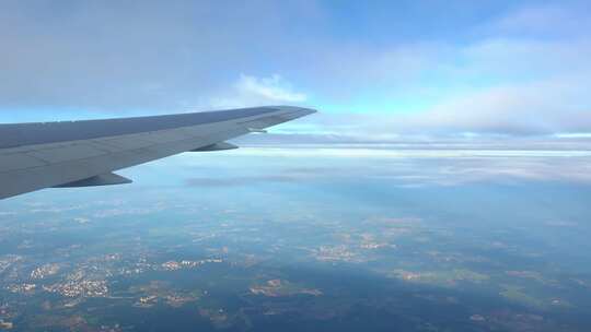 从窗户看飞机侧面的陆地景观。舷窗中的飞机