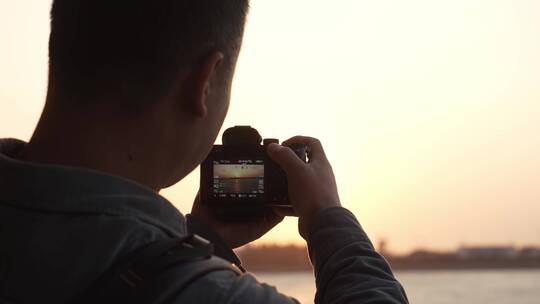 摄影师在轮船甲板上拍摄海上夕阳