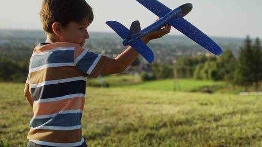 拿着飞机模型在草坪上玩耍的男人
