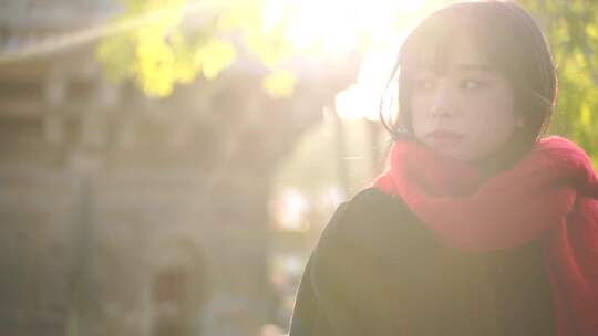 一个戴红色围巾的女人站在阳光下看远方风景视频素材模板下载