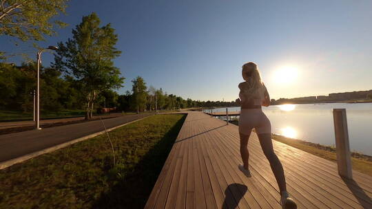 女子清晨在湖边跑步健身