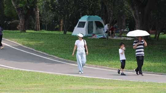 一家三口走在公园道路上面