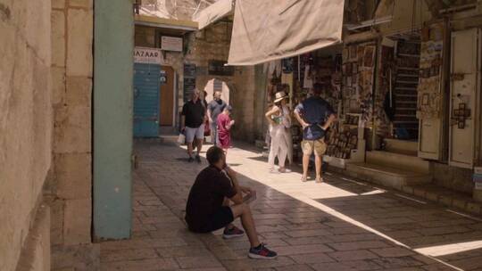 游客在耶路撒冷街头的商店购买纪念品