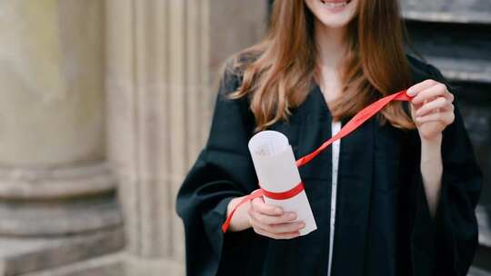 一个摘下丝带并展开大学文凭的女人