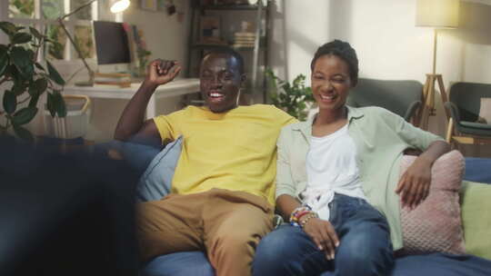 快乐的黑人夫妇在家看电视