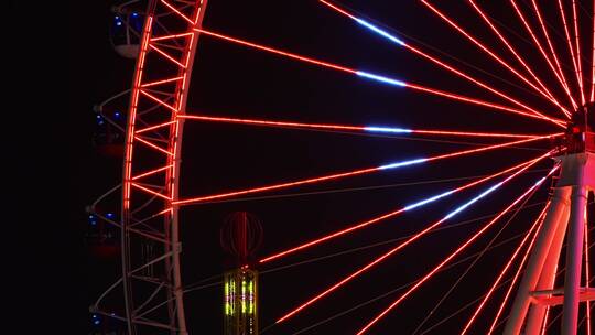 巨型摩天轮灯在晚上霓虹闪烁