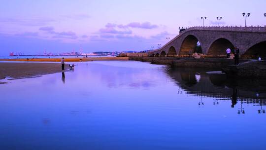 威海滨海沙滩石桥与黄昏海边钓鱼人