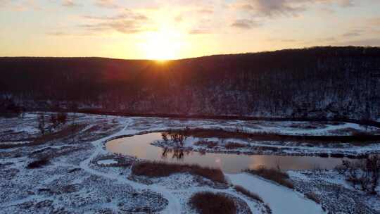 空中日落阳光照耀着冬天的河谷