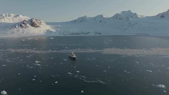航拍小船航行在冰山冰川之间斯瓦尔巴特群岛