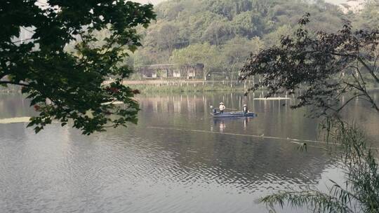 清洁工人坐小船在水污染的湖面清漂