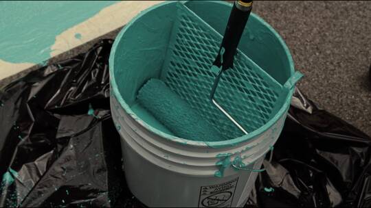 在油漆桶上蘸漆滚筒视频素材模板下载