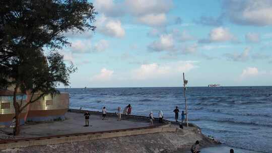 人们在海边沙滩上游玩的欢乐场景