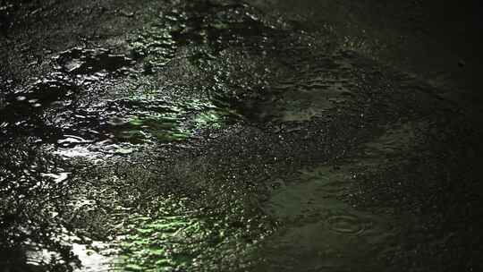 夜晚雨滴落在地面上