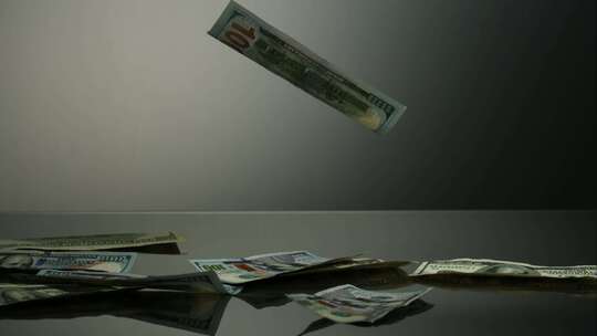 美国100美元的钞票落在反光面上