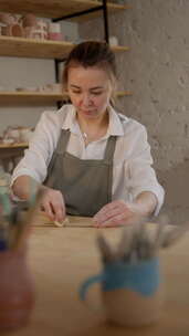 深思熟虑的女性波特在创意工作室中回顾陶器