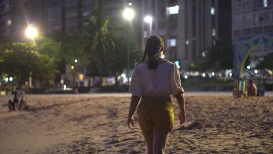 夜间的海滩上行走的女人