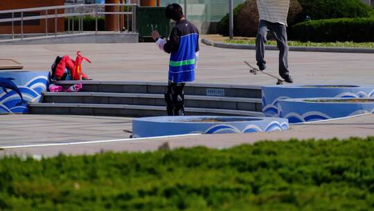 广场空地练习滑板的少年